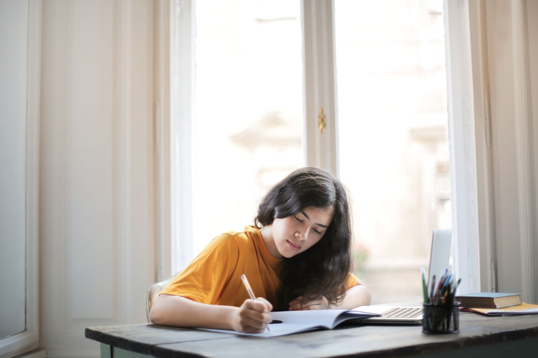 a woman in mustard shirt studying