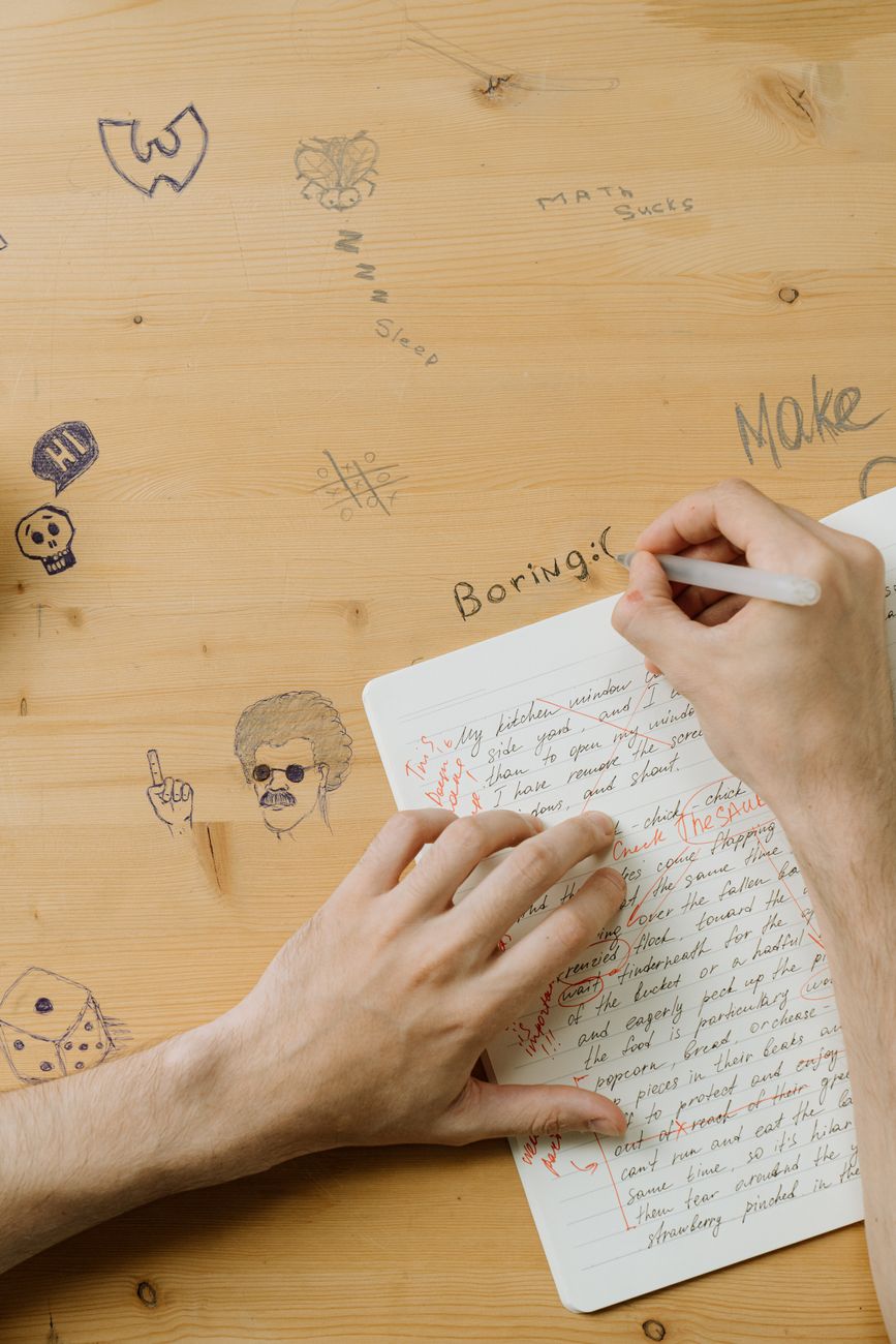 person writing on wooden surface