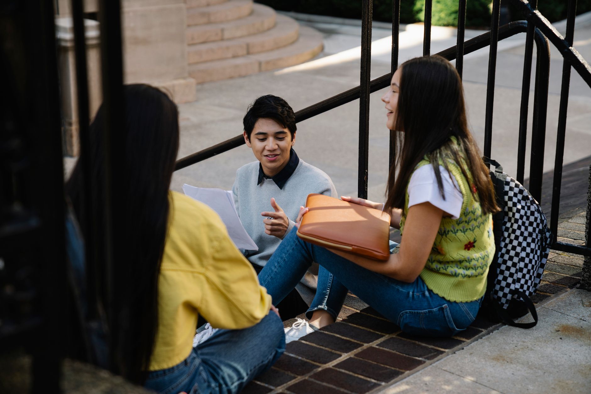 photograph of a man in a gray sweatshirt talking with his friends