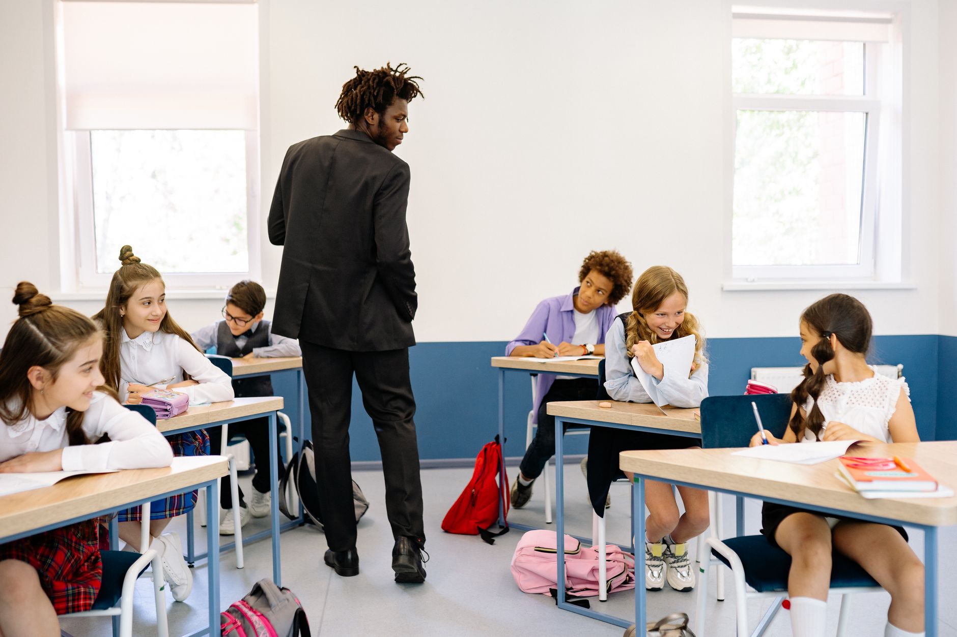teacher standing among students in classroom